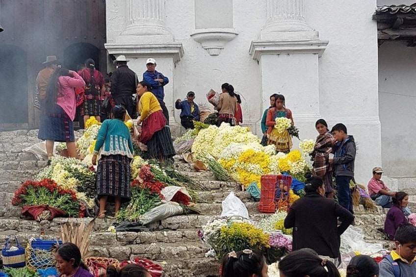 A group of people arranging flowers in front of a white building with columns. 2