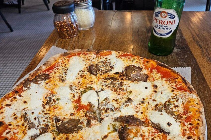 A pizza with toppings on a wooden table. 2