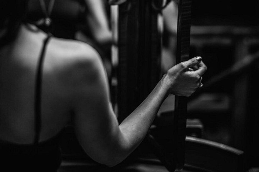 A person in a black dress, holding onto a railing. 5