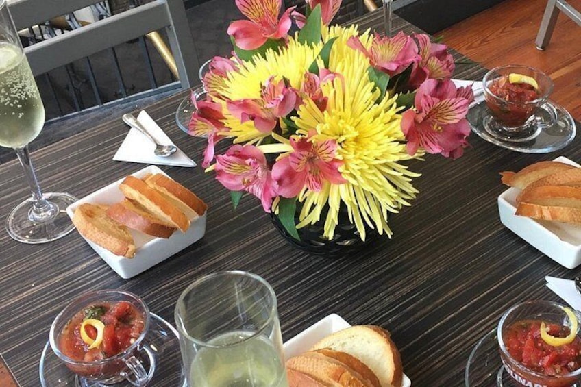 Ett bord med bröd, en vas med blommor och glas med dryck. 5