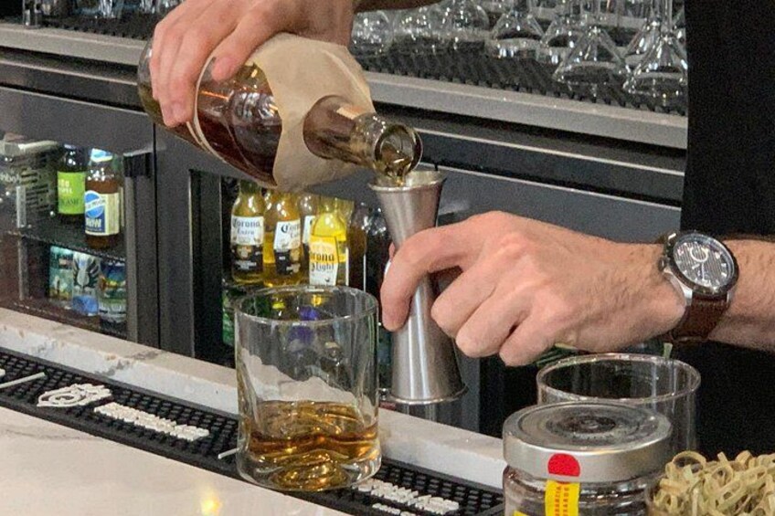 A person pouring a liquid from a bottle into a glass. 5