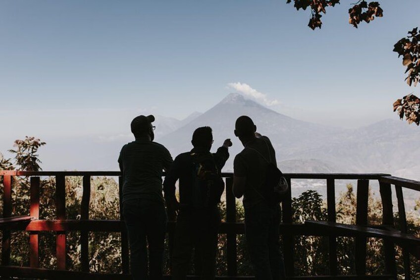 A group of people standing on a wooden platform overlooking a mountain. 2