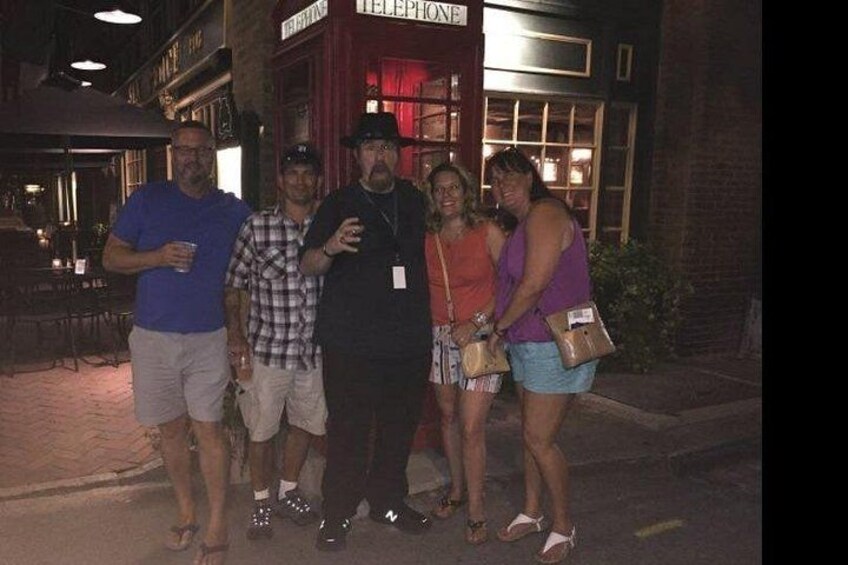 A group of people standing outside a building with a sign that reads 'TELEPHONE.' 2