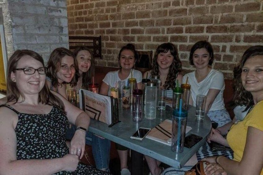 A group of people seated at a table with drinks and a menu. 3