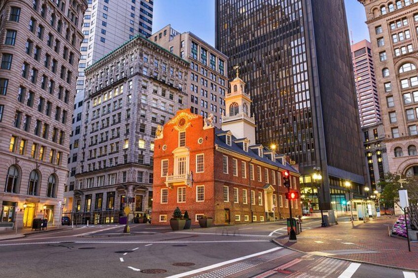 A city intersection with tall buildings, a historic red brick building, and a traffic light. 2