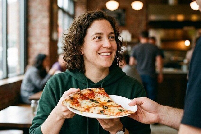 Une personne tenant une assiette avec une part de pizza. 4