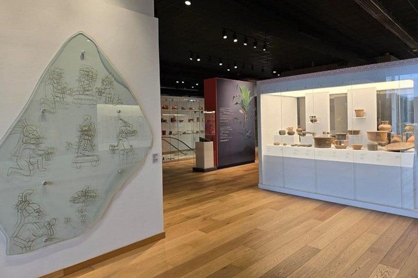 Une galerie d’art dotée de planchers en bois et de vitrines en verre où sont exposées des pièces de poterie. 3