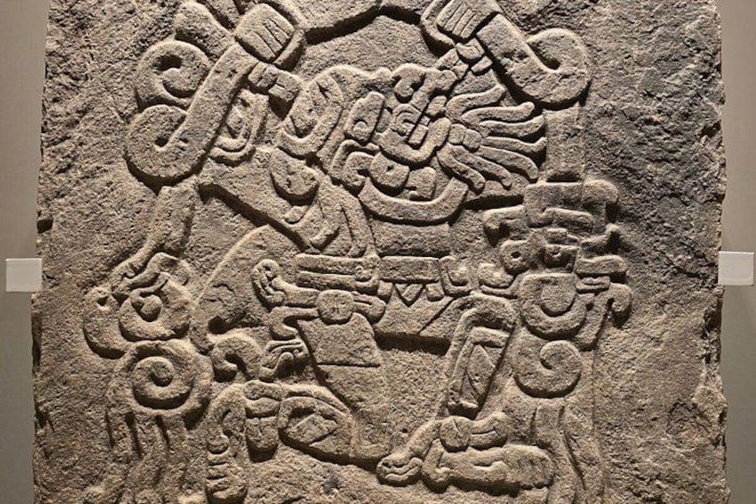 Une pierre sculptée ornée de glyphes et de motifs complexes, qui pourrait avoir une importance culturelle ou historique. 4