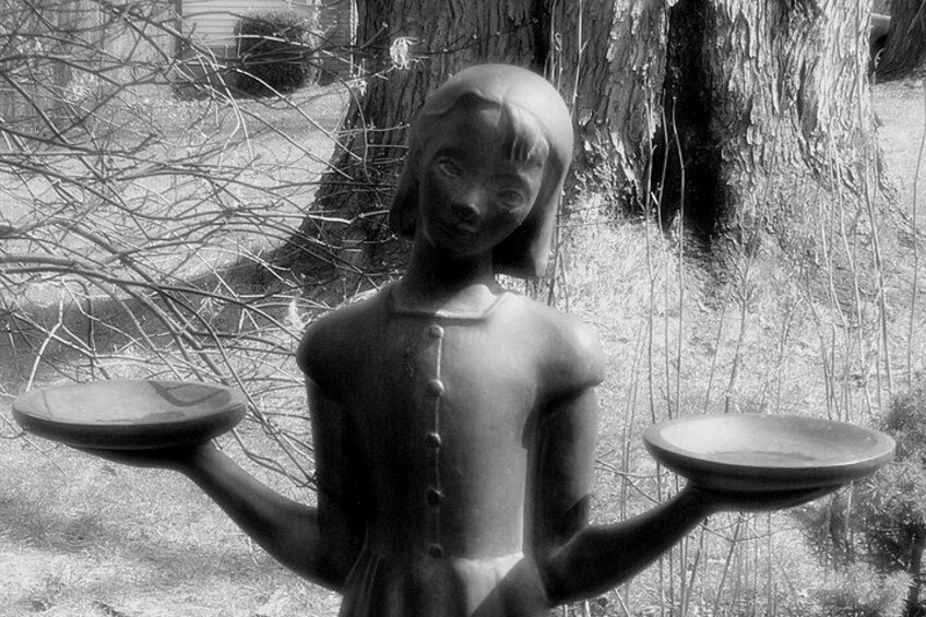 En skulptur som föreställer en figur som håller i en våg. 2