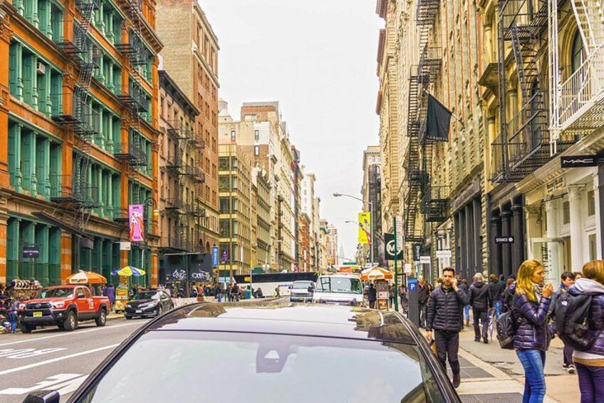 Una calle urbana concurrida, con peatones, vehículos y edificios históricos. 4