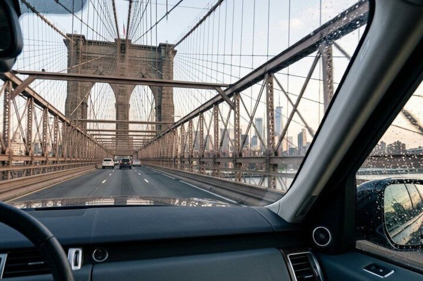 Un'auto che percorre un ponte con lo skyline di una città sullo sfondo. 1