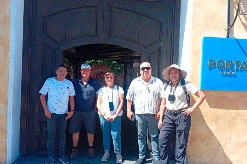 Un grupo de personas de pie frente a un edificio con un letrero azul que dice 'PORTA'. 5