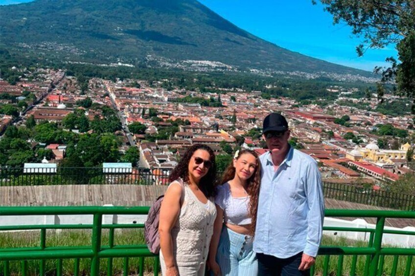 Tres personas frente a un paisaje urbano con una montaña al fondo. 3