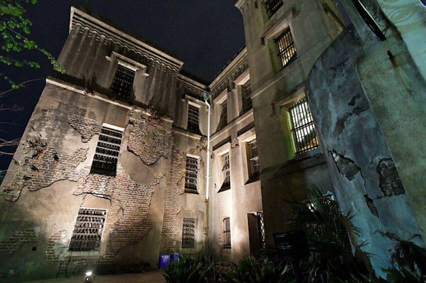 Un bâtiment historique aux fenêtres illuminées et orné d’une fresque sur sa façade inférieure. 4