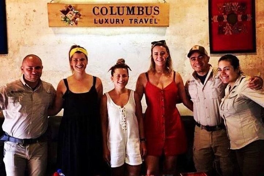 Un groupe de personnes se tient devant une enseigne sur laquelle on peut lire : « COLUMBUS LUXURY TRAVEL ». 3