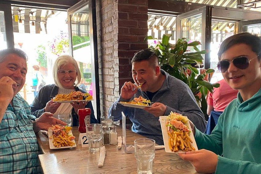 Mensen eten in een restaurant, met eten en drinken op tafel. 1