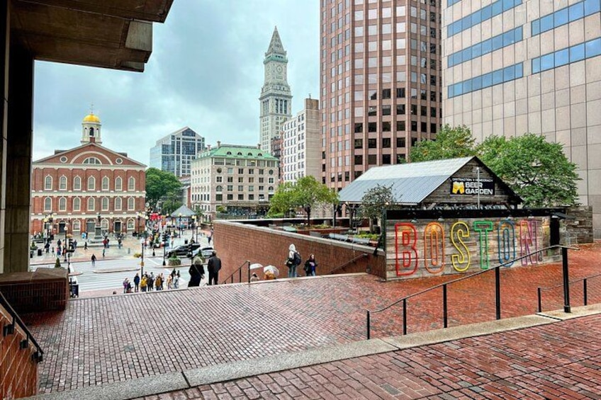 A cityscape with a prominent red building, a modern glass building, and a sign reading 'BOSTON.' 5