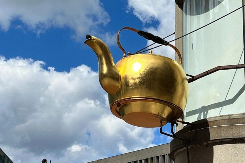 Ein goldener Teekessel an einem Gebäude befestigt. 4