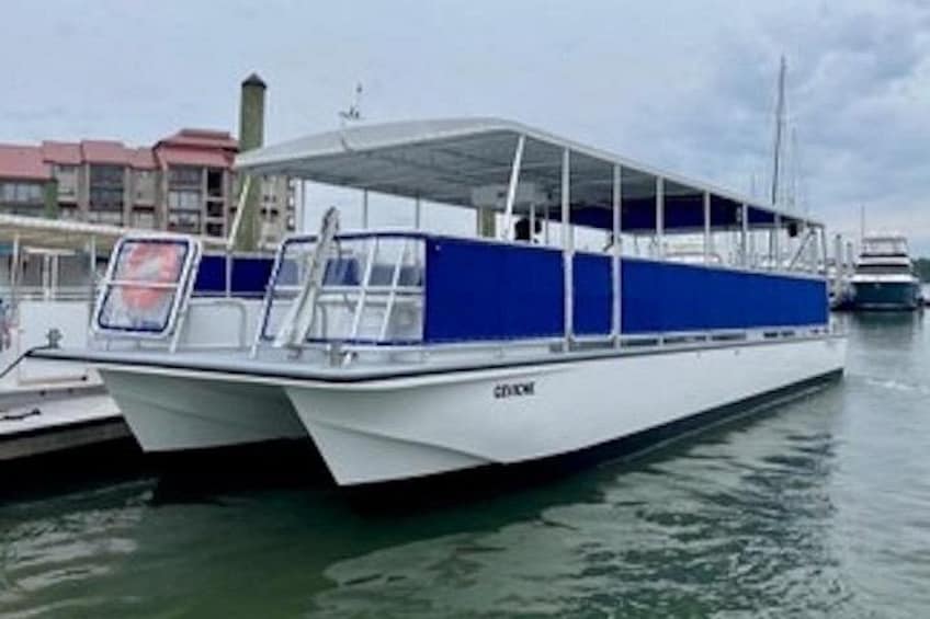 Ein weißes und blaues Boot liegt in einer Marina vor einer Gebäudereihe. 3