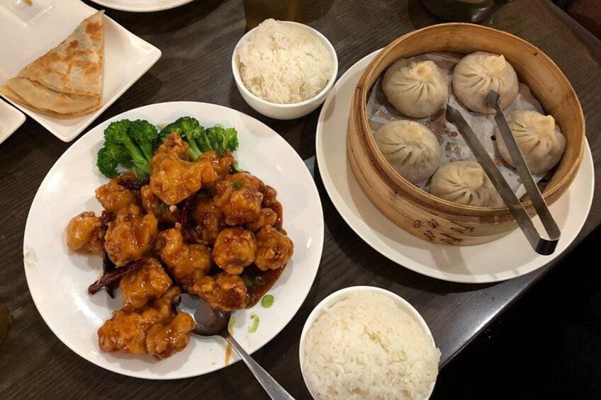 A plate of fried chicken, a bowl of rice, a plate of dumplings, and a plate of broccoli. 5