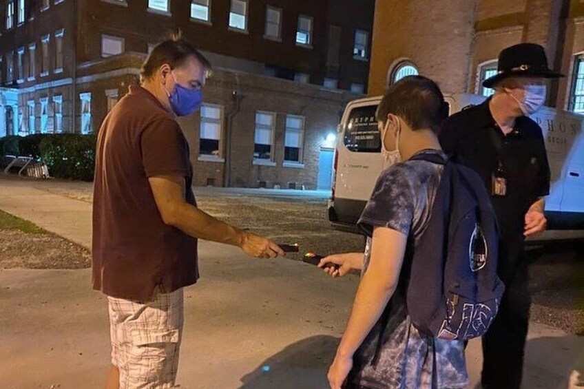 Small Blue Orb on the ground between Guests Holding K2 EMF meters registering EMF spike. 2
