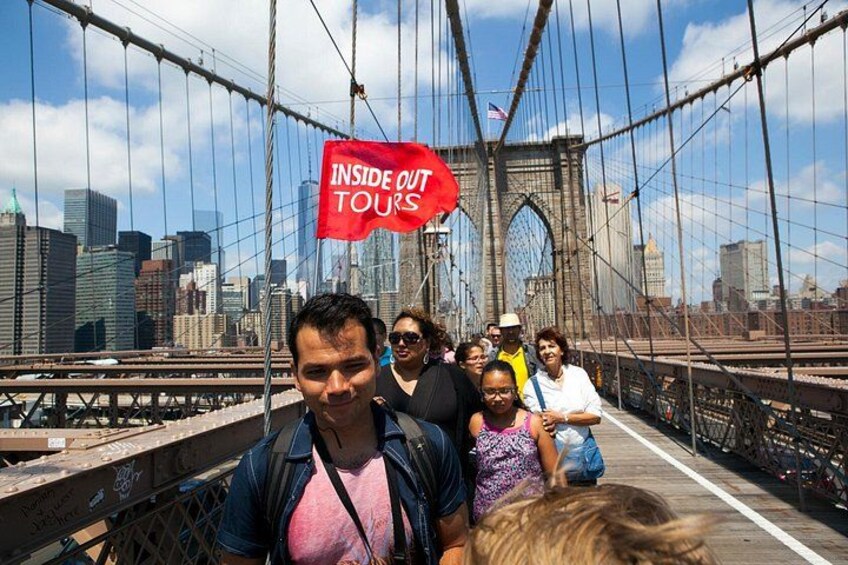 Un grupo de personas en un puente con un cartel que dice 'INSIDE OUT TOURS'. 2