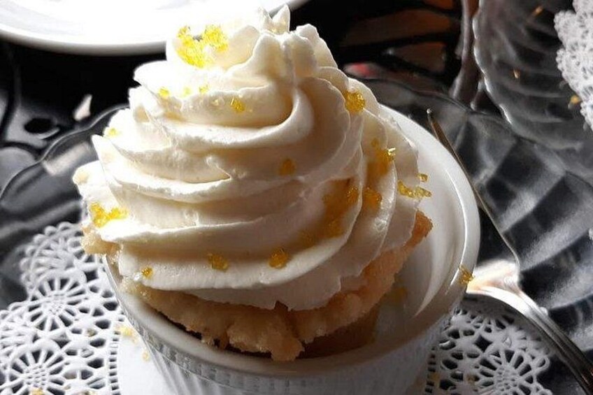 Ein Dessert in einer weißen Schale mit Schlagsahne und Zitronenschale. 2