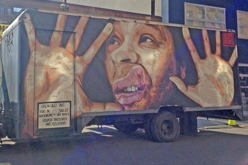 A truck with a large mural of hands on its side. 3