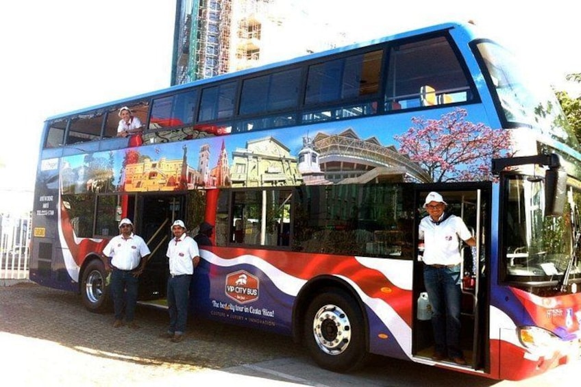 Een dubbeldekkerbus met een stadsgezicht en kersenbloesems op de zijkant. 1