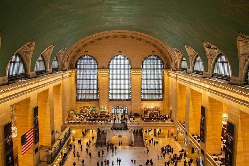 A spacious train station with high arched ceilings and large windows. 1