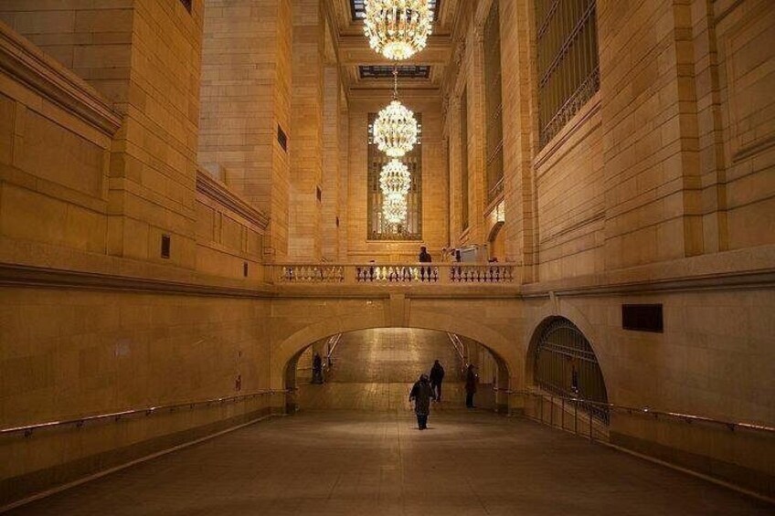 A grand hall with a large chandelier, arched ceilings, and a central staircase. 3