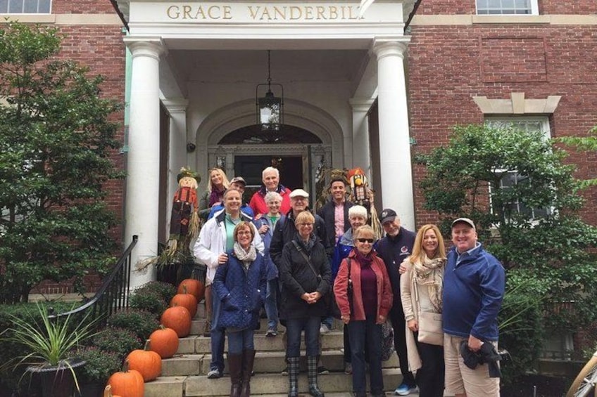 A group of people standing in front of a building with a sign that reads "GRACE VANDERBILL." 5