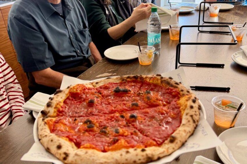 A large pizza with pepperoni and mushrooms on a wooden table. 3