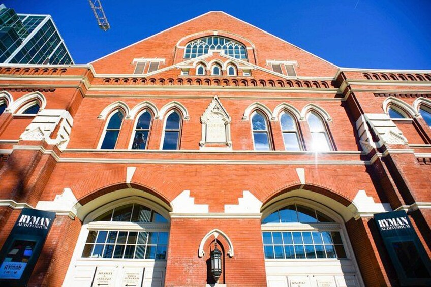 A red brick building with arched windows and a central clock tower. 2