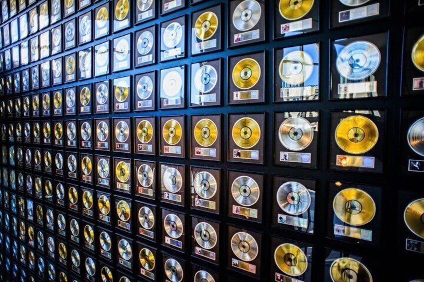 Eine Wand mit goldenen und silbernen Schallplatten in Schutzhüllen. 5