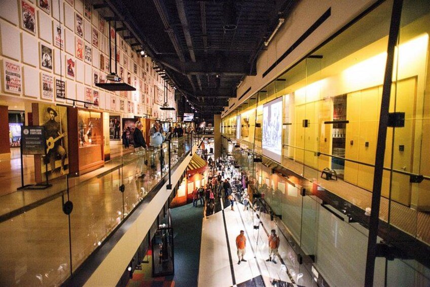 An indoor shopping mall with multiple levels, glass railings, and various shops. 3