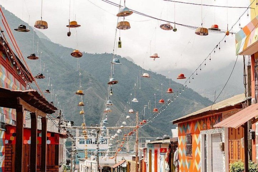 A street with colorful buildings and a mountain in the background. 2