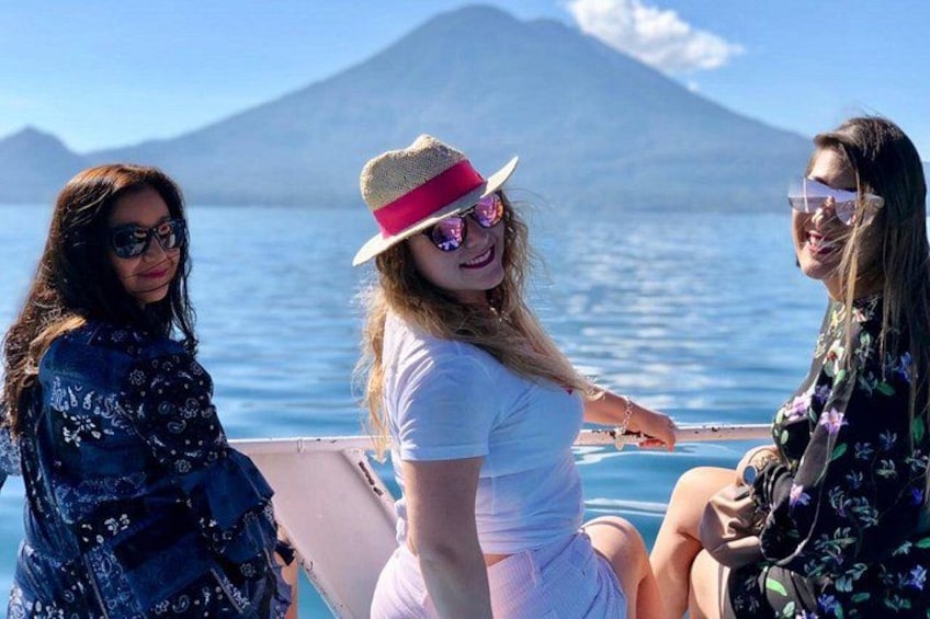 Three people on a boat with a mountainous landscape in the background. 1