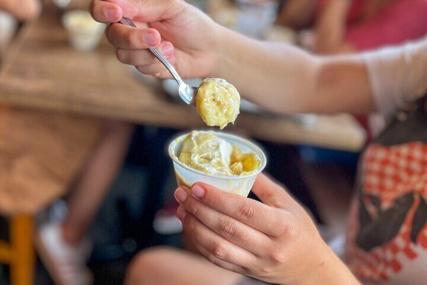 A person scooping ice cream from a cup. 3