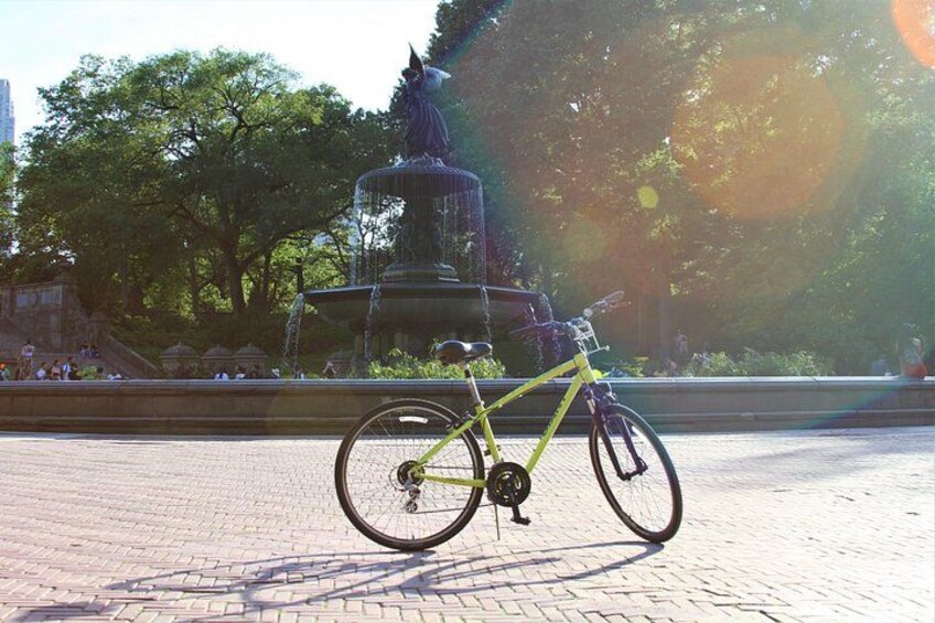 Un vélo est garé devant une fontaine dans un parc. 4