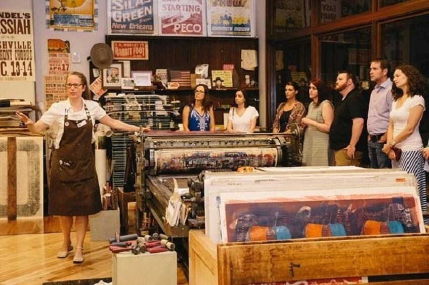 Interior de una tienda vintage con diversos artículos expuestos, incluyendo una máquina de coser grande y estantes llenos de telas. 2