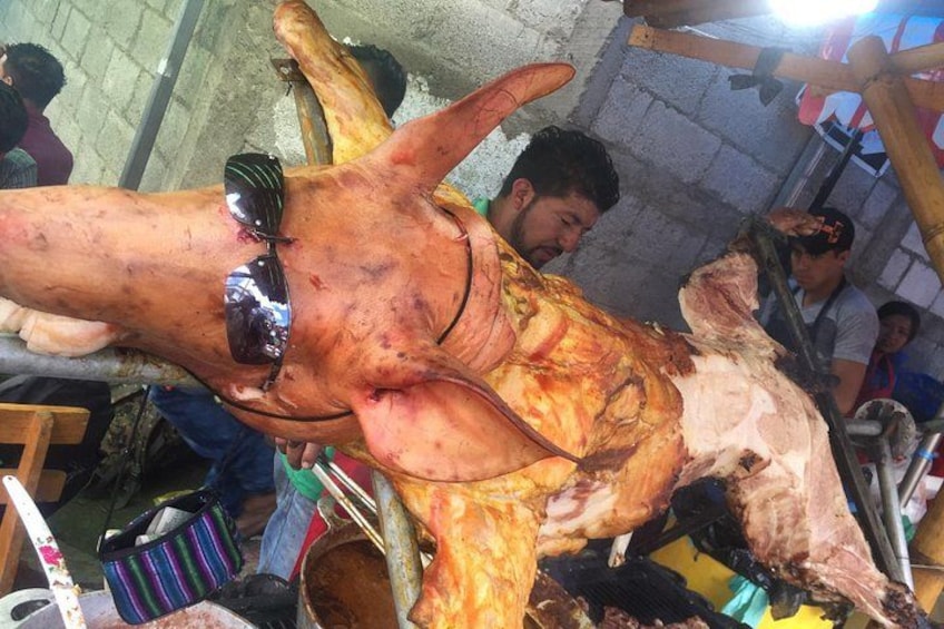 A large animal carcass being prepared, with people around it. 4