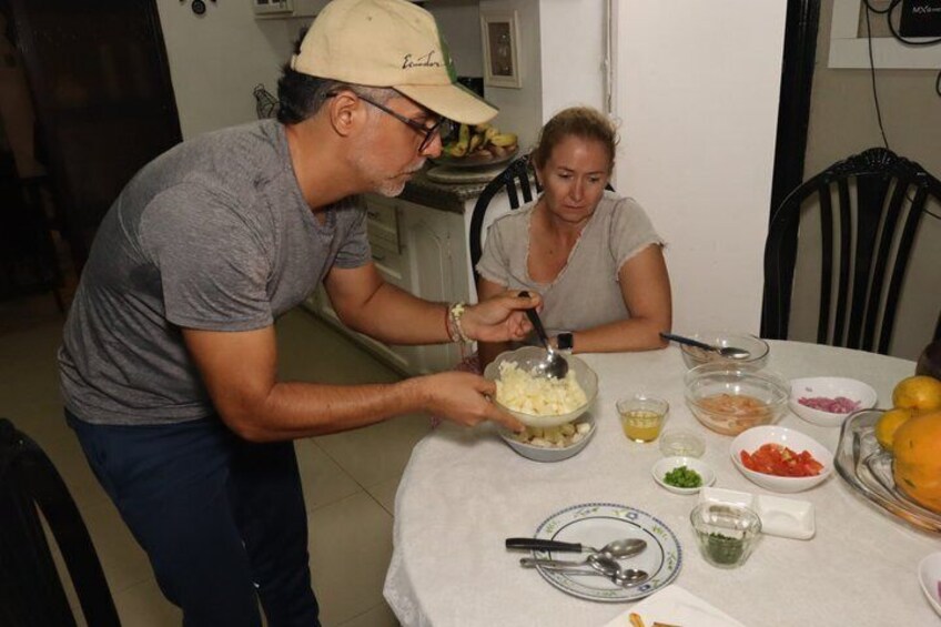 Una persona preparando comida en una mesa con diversos ingredientes y utensilios. 3