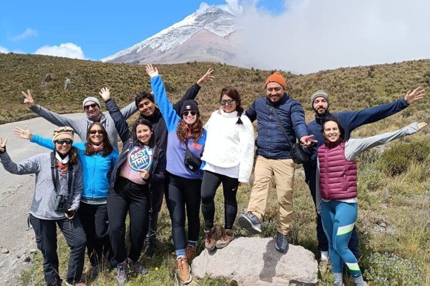 A group of people standing on a road with a mountain in the background. 3