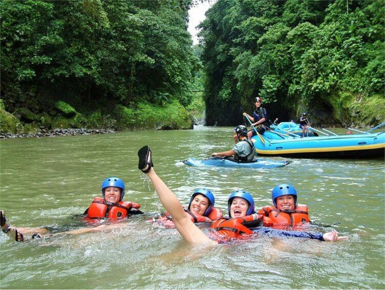 People rafting on a river surrounded by dense greenery. 4