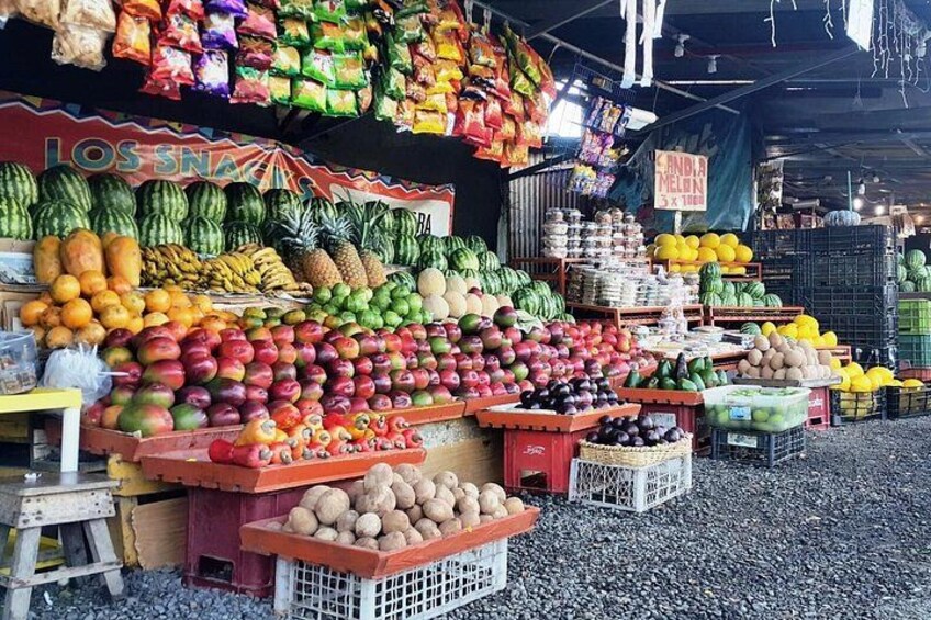 A fruit and vegetable market with various produce displayed in crates and baskets. 3