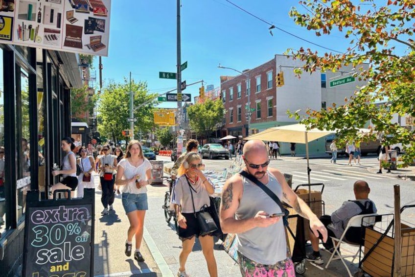 A busy street with pedestrians, a sign offering a 30% discount, and a street sign for 'Seventh Ave.' 4