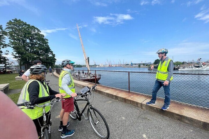 Personas en bicicleta cerca de la costa, usando chalecos reflectantes y cascos. 3