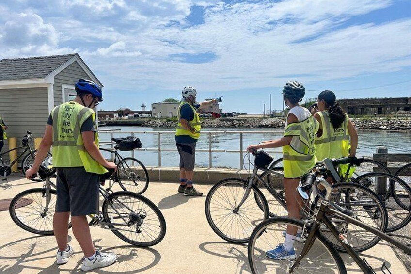 Cyclists wearing safety vests by a waterfront. 4
