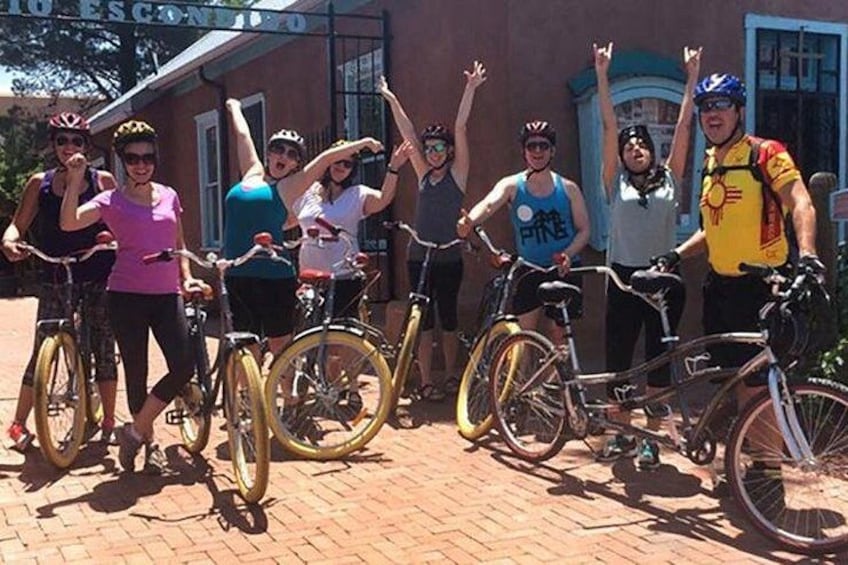 Un groupe de cyclistes pose avec leurs vélos devant un immeuble. 2